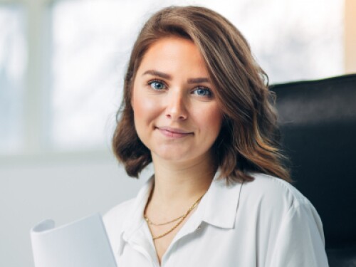 professional in a conference room holding a report and smiling