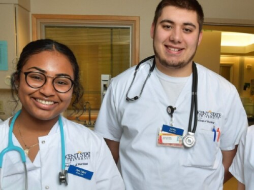 nursing students wearing stethoscopes smile in hospital room