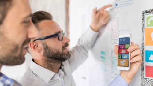 user experience designers wireframe app on a whiteboard