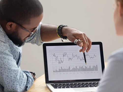 Teacher pointing at charts in front of student