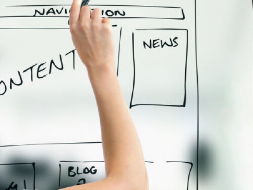 user experience designer draws wireframes on whiteboard