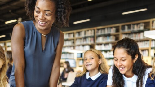 librarian talking with students in a library