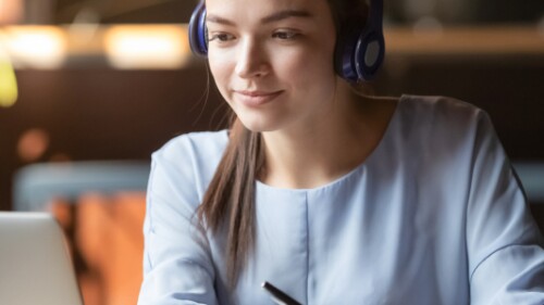 student wearing headphones working on laptop