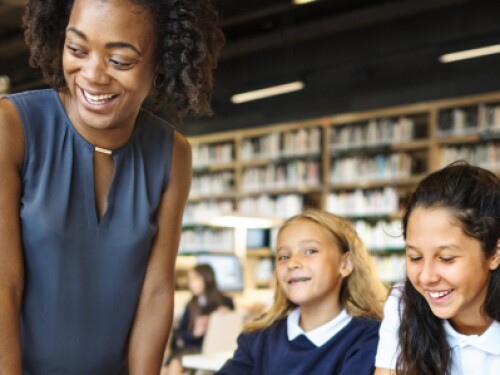 librarian talking with students in a library