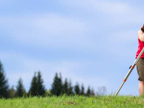 surveyor on a hill, trees in the background
