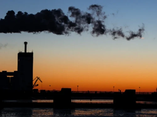 Smoke from a factory barrels through the night air