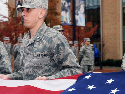 military service members hold United States flag