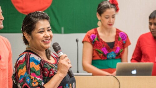 professionals dressed in bright cultural attire giving a presentation