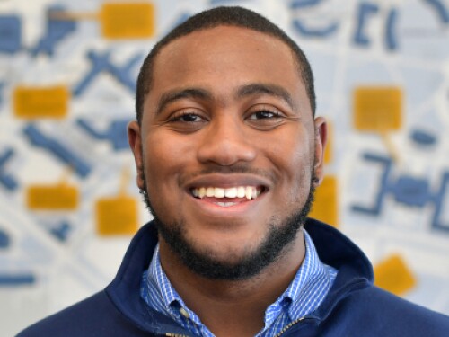 young black man standing in front of a map of Kent State University's campus