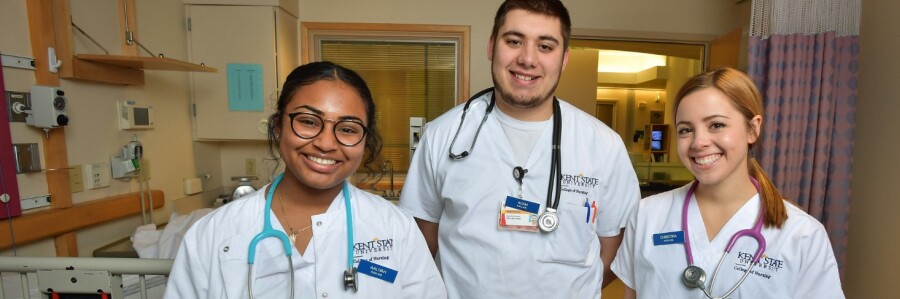 nursing students wearing stethoscopes smile in hospital room