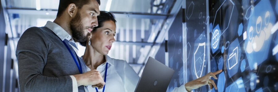 tech professionals working on large digital screen with abstract images