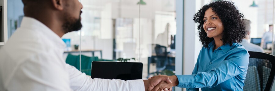two professionals shake hands in an office