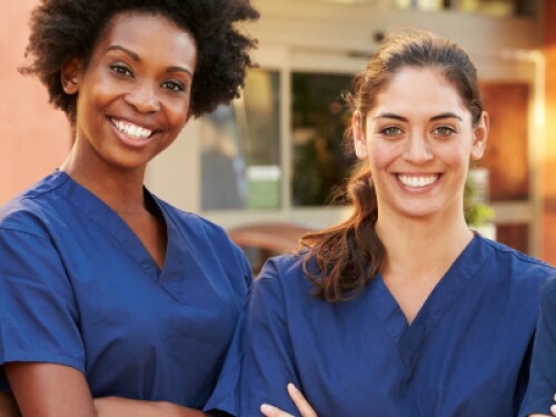 four nurses stand with arms crossed and smiling