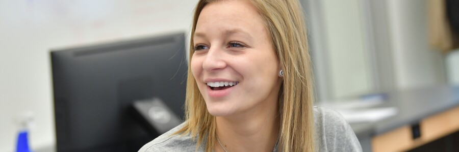 student smiling in a classroom