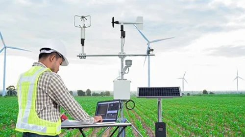 Scientist collects data in a windmill field