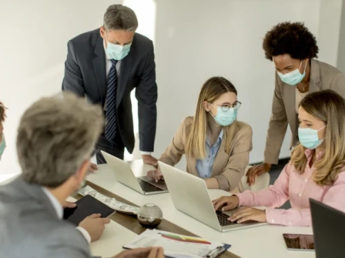 group of people wearing masks in a meeting