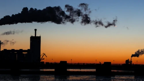 Smoke from a factory barrels through the night air
