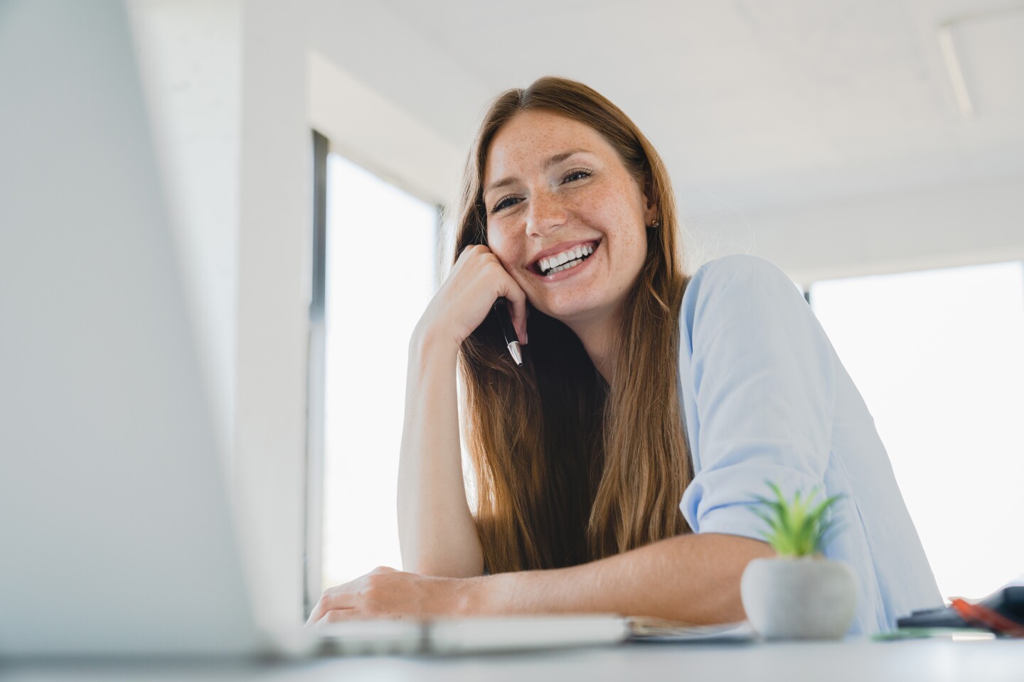 Happy,Young,Caucasian,Woman,Working,On,Laptop,Laughing,At,Office