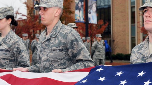 military service members hold United States flag