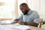 Focused,African,American,Man,Student,Freelancer,Making,Notes,Studying,Working