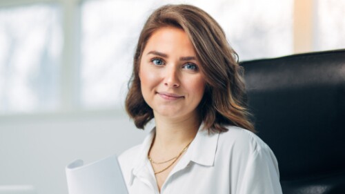 professional in a conference room holding a report and smiling