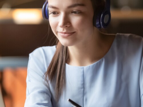 student wearing headphones working on laptop