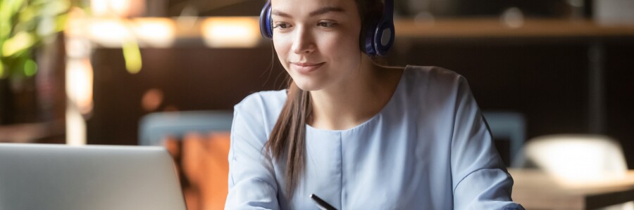 student wearing headphones working on laptop