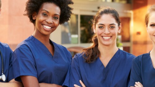 four nurses stand with arms crossed and smiling