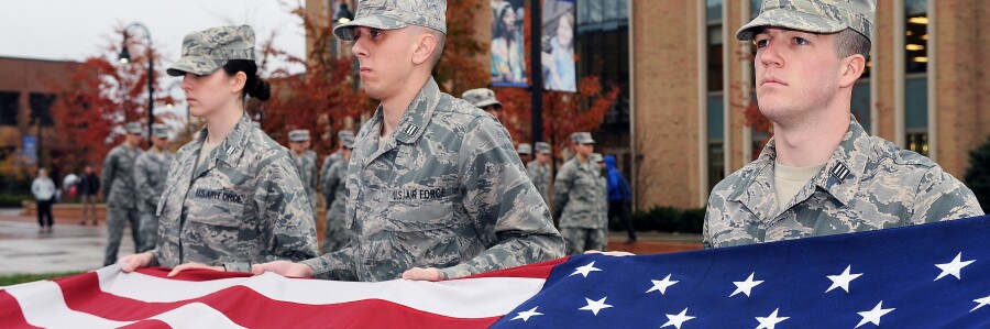 military service members hold United States flag
