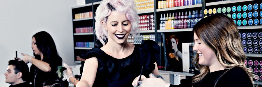 professional hairstylist training a stylist student on hair coloring treatment