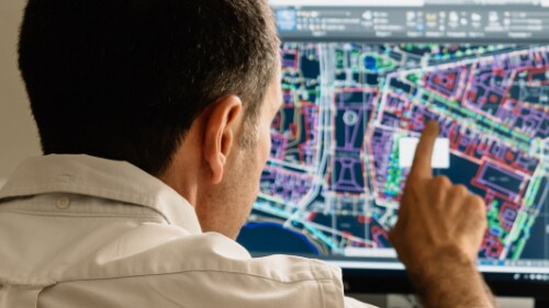 technologist pointing to at a digital map on computer monitor