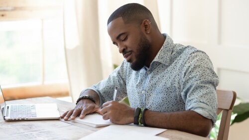 Focused,African,American,Man,Student,Freelancer,Making,Notes,Studying,Working