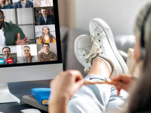 student with feet on desk participating in virtual group conference from comfort of home