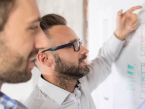 user experience designers wireframe app on a whiteboard