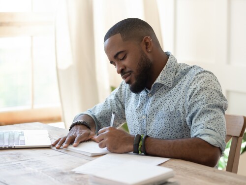 Focused,African,American,Man,Student,Freelancer,Making,Notes,Studying,Working