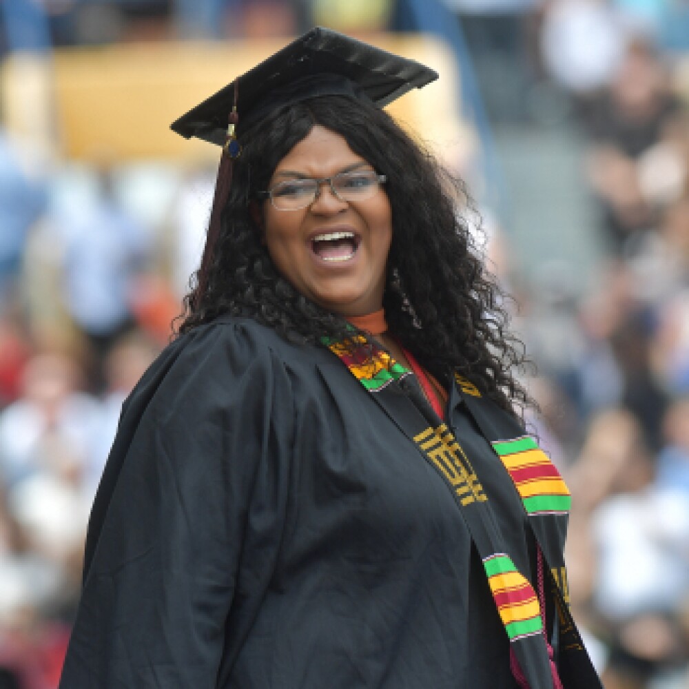 smiling graduate wearing cap, gown, and stole