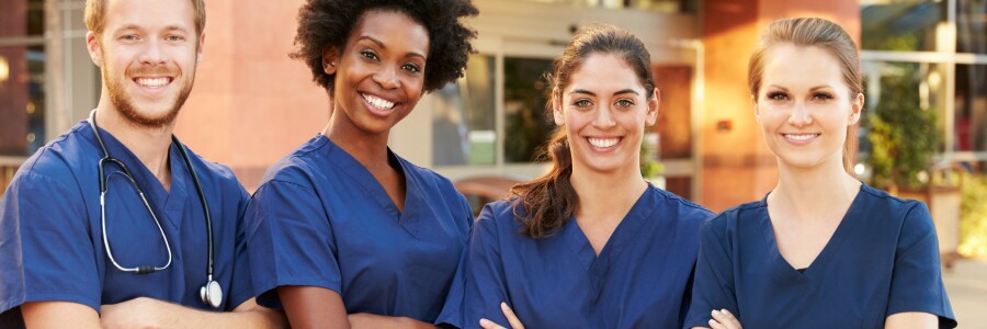 four nurses stand with arms crossed and smiling